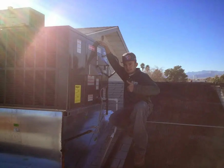 HVAC technician performing Boiler Repair on a rooftop unit in Idylwood